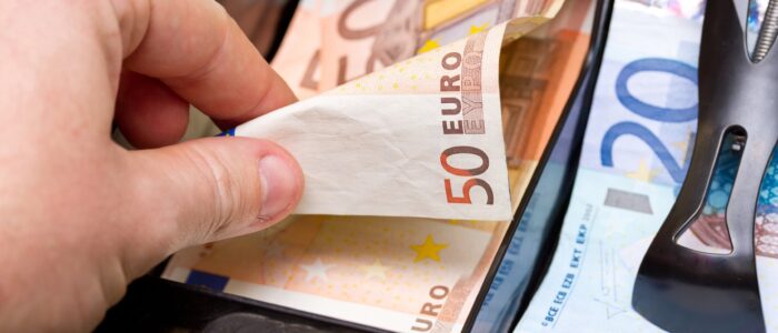 Hand giving change in euro from the till