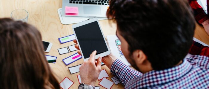 People at office working on digital tablet planning responsive website design